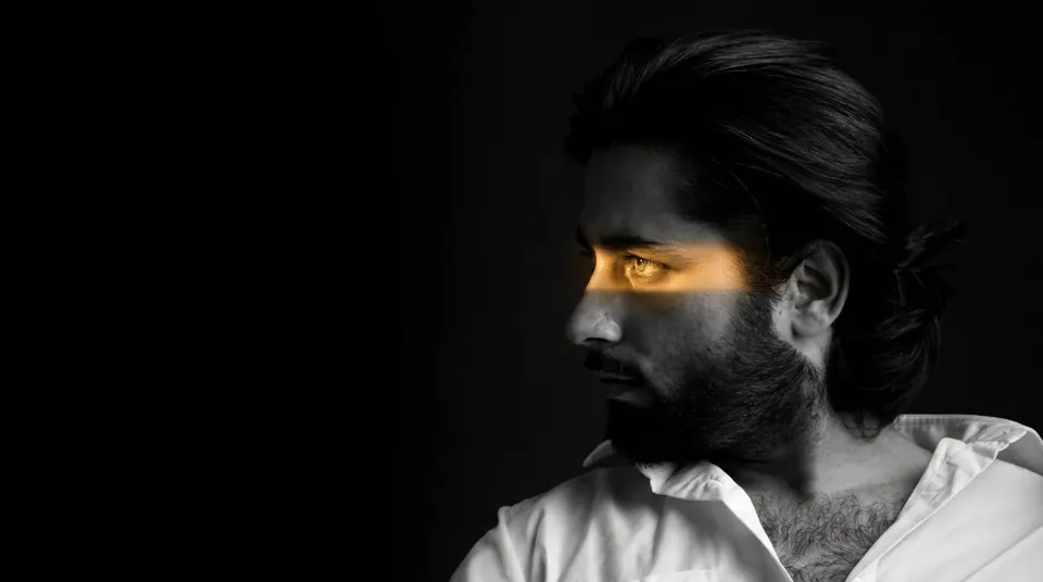Cinematic portrait of a man looking left with yellow light across his eyes