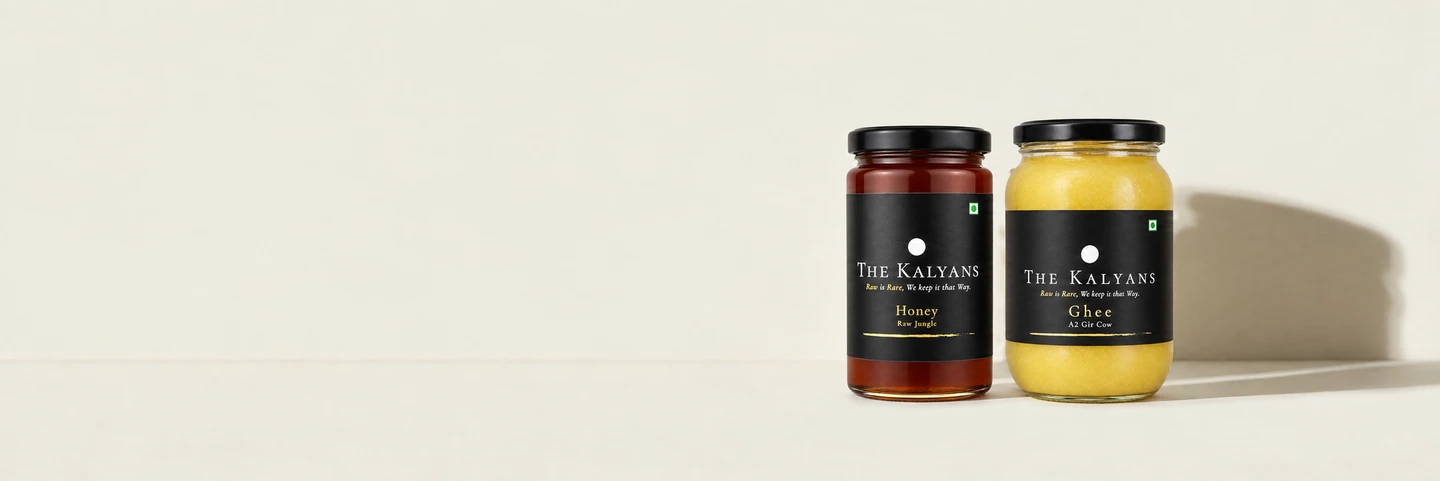 The Kalyans Raw Jungle Honey and A2 Gir Cow Ghee jars on a light background